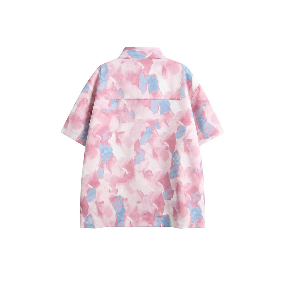 Back view of a short-sleeve collared shirt with an allover pink, white, and blue abstract print.