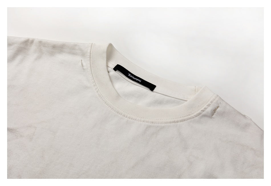 Close-up of a pale gray T-shirt crew neckline, ribbed collar, and black inner neck label.