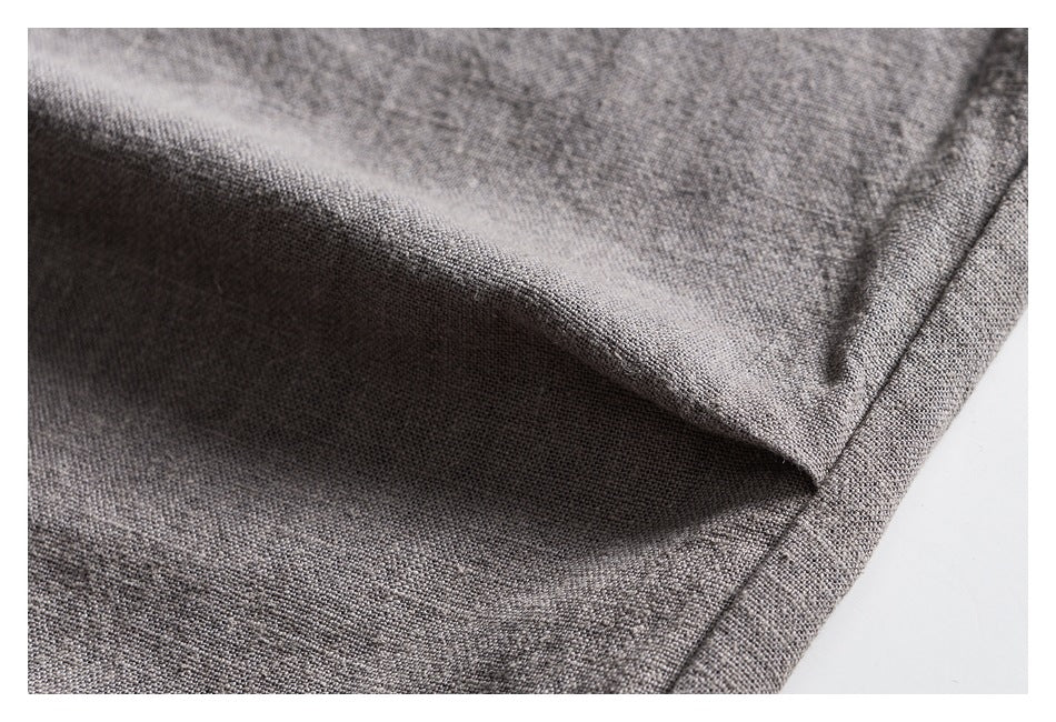Macro view of gray trouser fabric folded near a stitched edge.