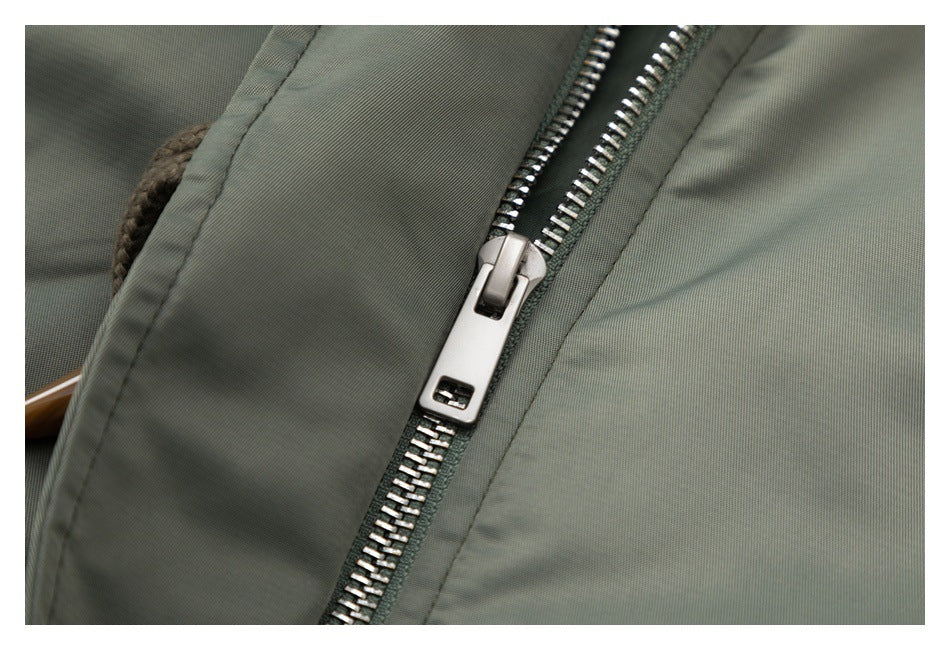 Close-up of a silver zipper on an olive-gray garment.