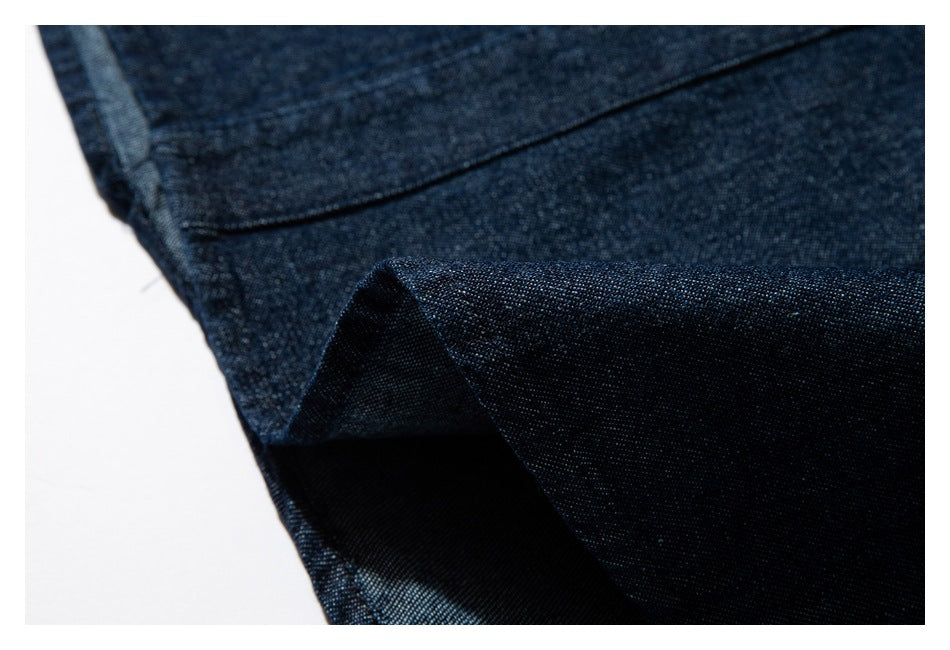 Close-up of a folded dark indigo garment edge with a visible seam and fabric texture.