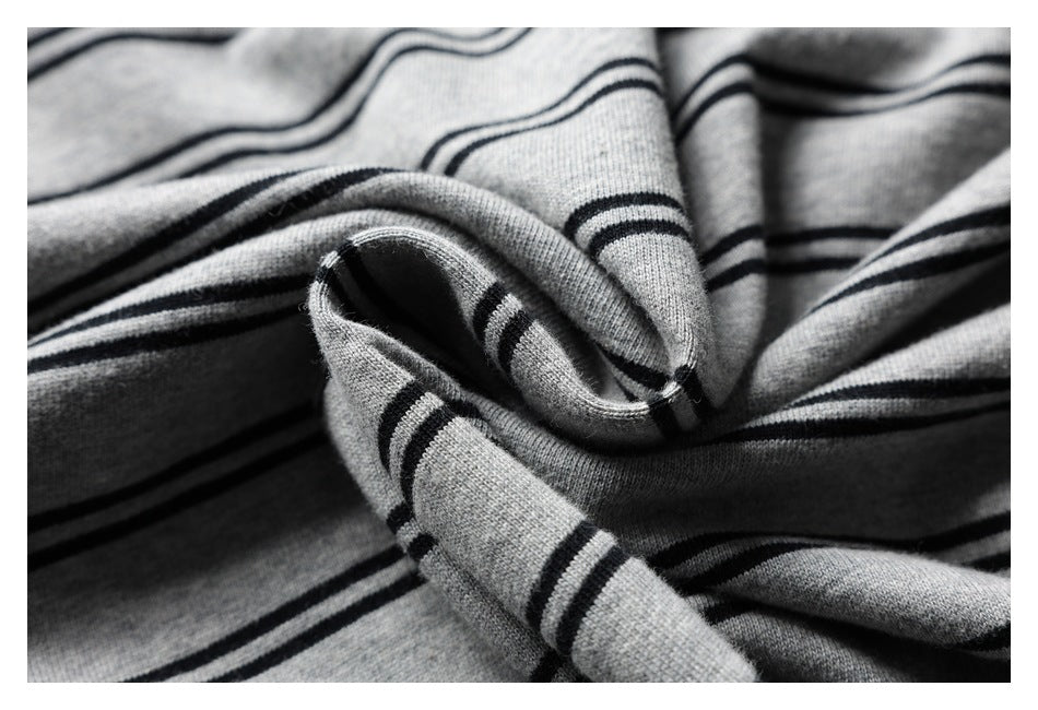 Close-up of gray striped knit fabric gathered into folds, showing its texture and edge.