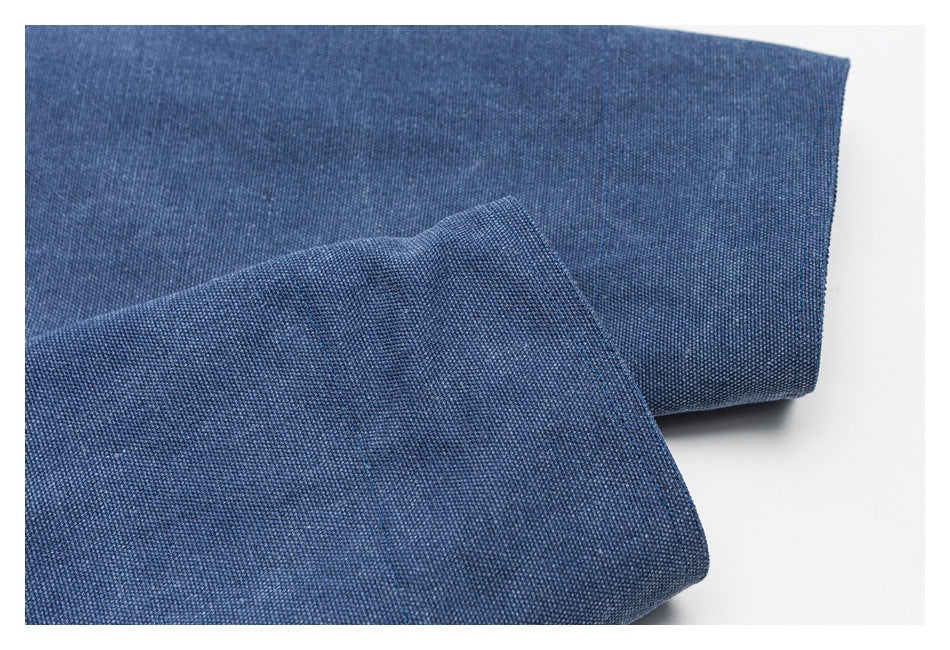 Close-up of layered blue fabric showing its woven texture and stitched edge.