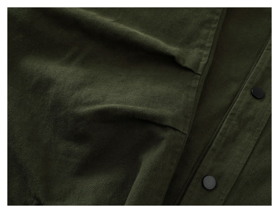 Close-up of a dark olive flap pocket and black snaps on the garment's front placket.
