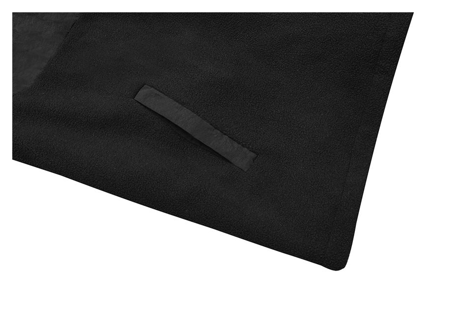 Close-up of black textured fabric with a narrow angled welt pocket opening.