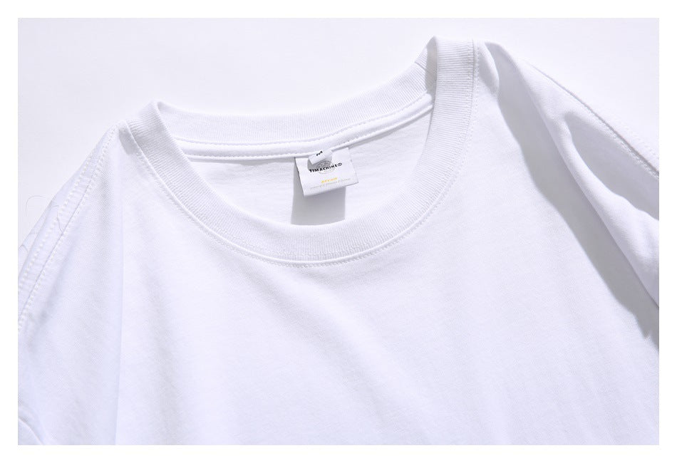 Close-up of a white T-shirt's ribbed crew neckline and small sewn-in neck label.