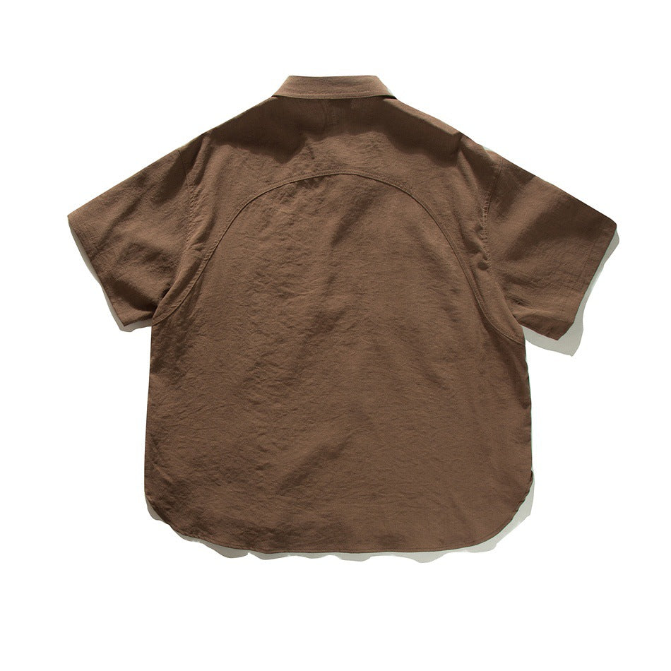 Back view of coffee brown short-sleeve shirt with curved yoke seam and rounded hem, flat lay
