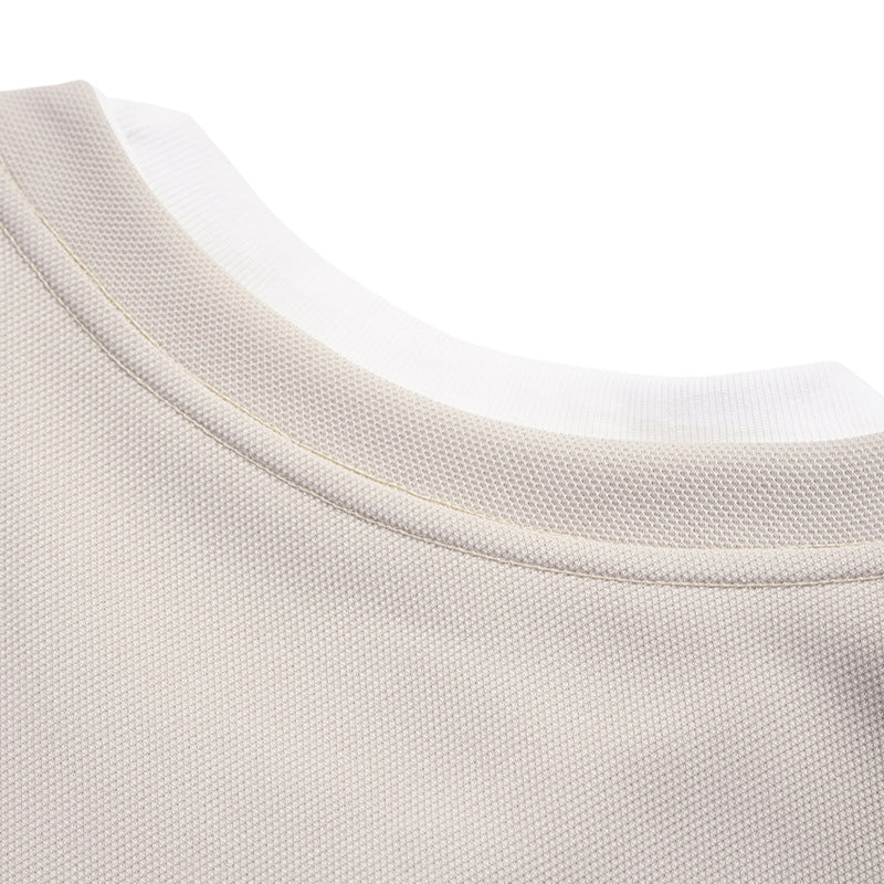 Close-up of the back neckline and stitched collar seam on a light beige shirt.