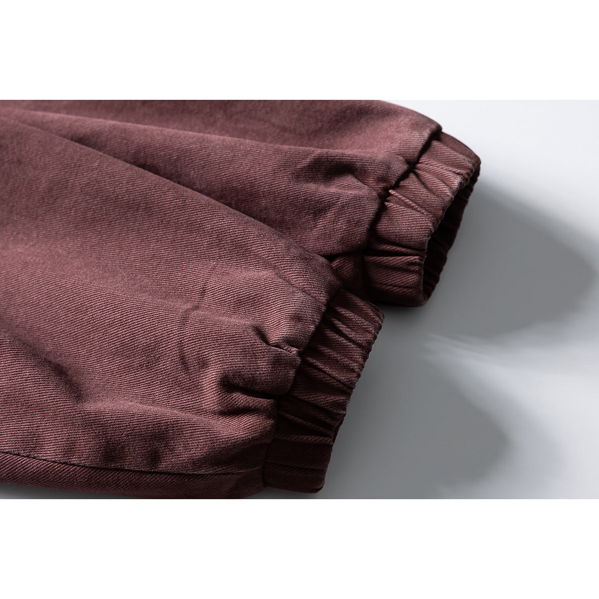 Close-up of the gathered elastic cuffs on a burgundy jacket sleeve.