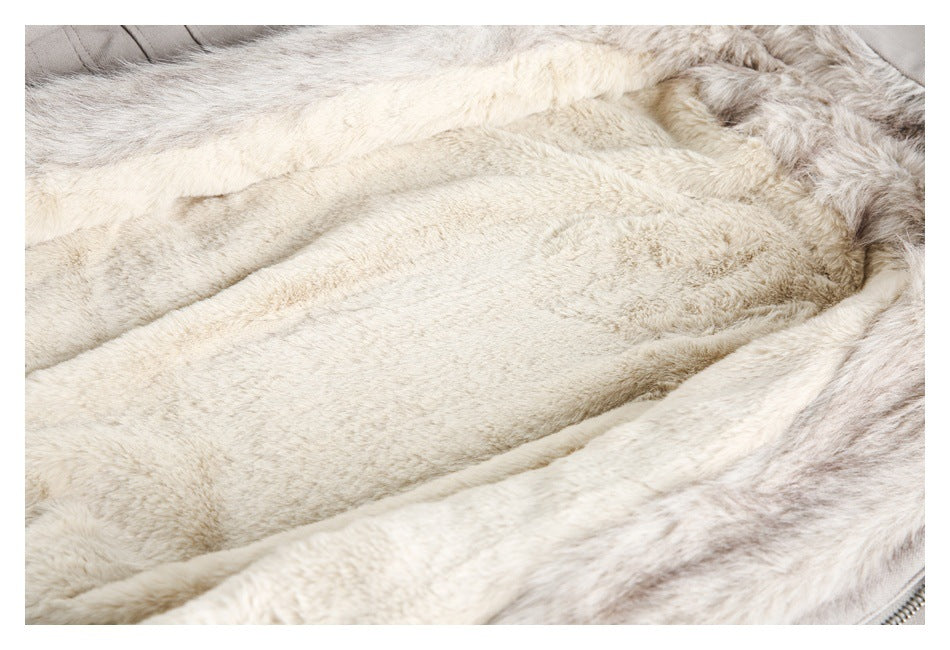 Close-up of cream plush fabric with soft folds and a small zipper edge visible at the lower right.