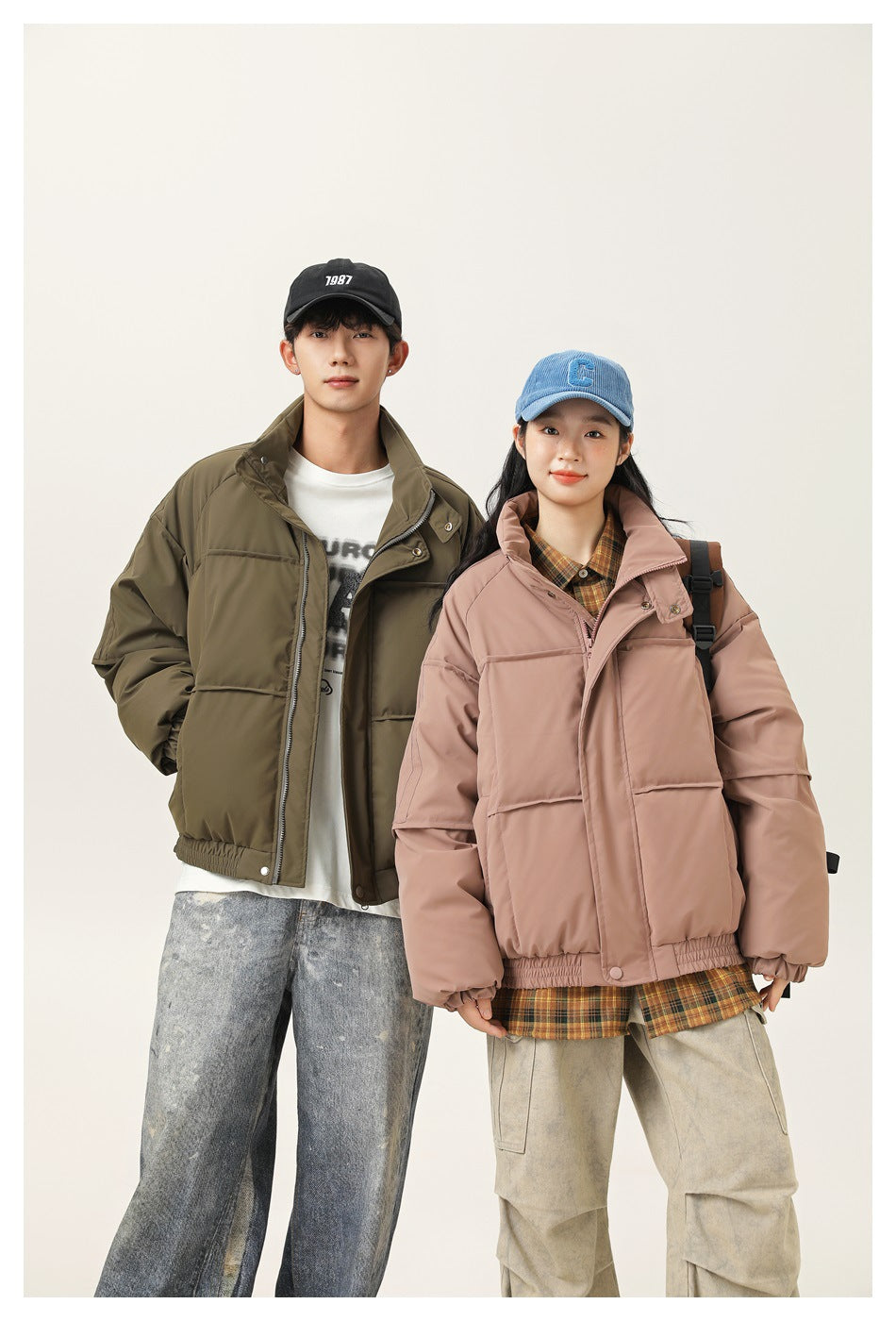 Two models wear oversized padded jackets: olive green and dusty pink, with high collars and elastic hems.