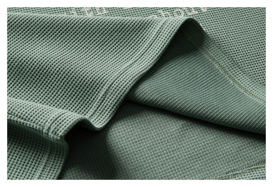Close-up showing the textured sage-green shirt fabric and its smoother inner surface.