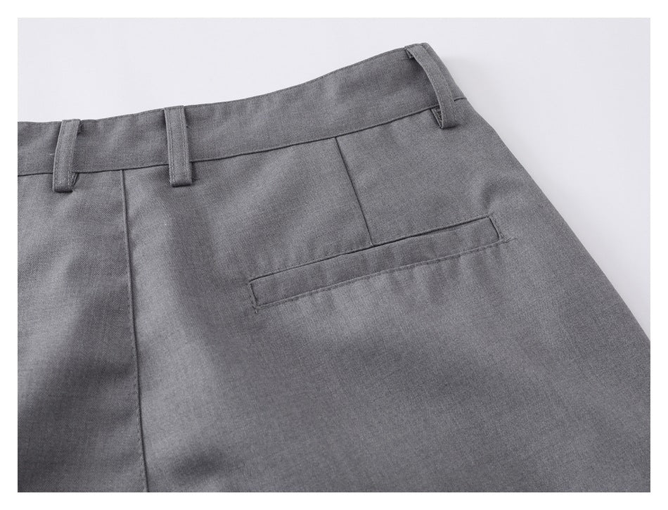Close-up of the rear welt pocket, waistband, and belt loops on gray shorts.