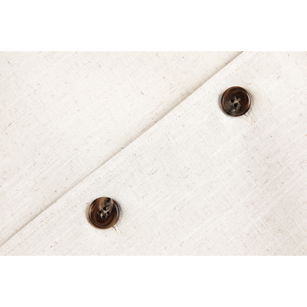 Close-up of two dark brown buttons on cream textured fabric.