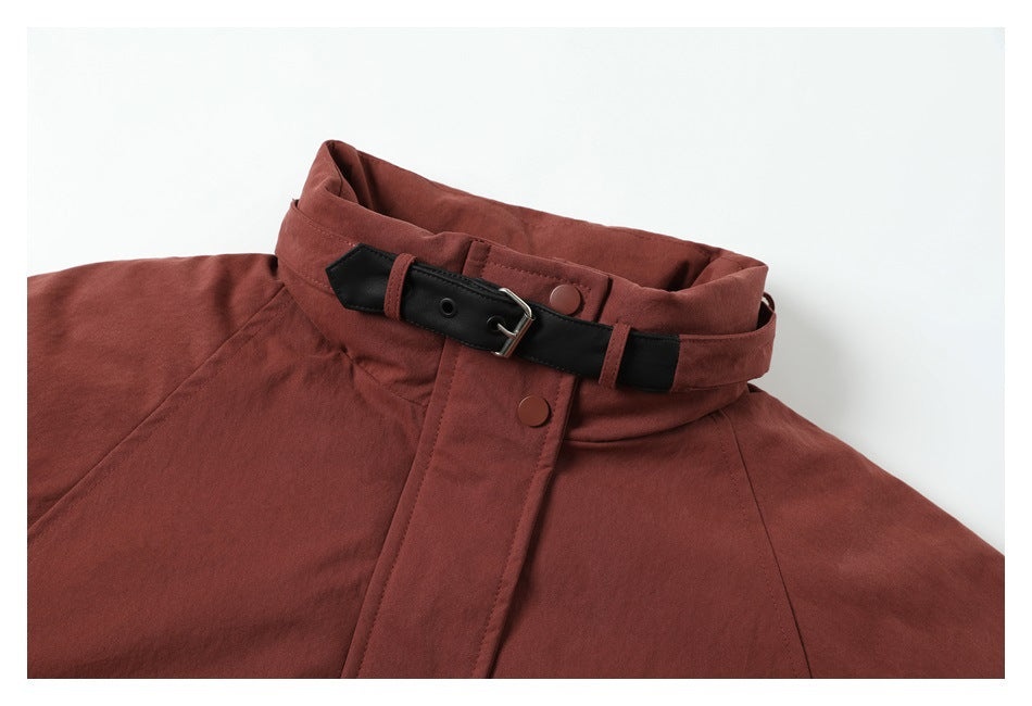 Close-up of the burgundy jacket's high collar, black buckle strap, and snap-button placket.