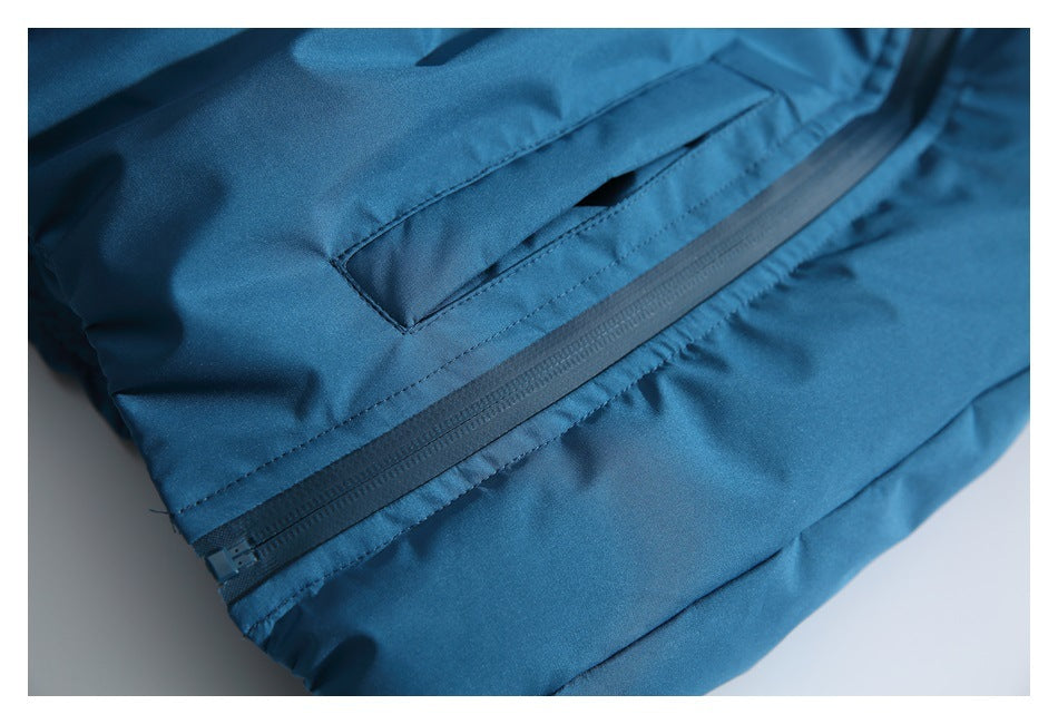 Close-up of a blue jacket showing a diagonal zipper and a nearby stitched pocket.