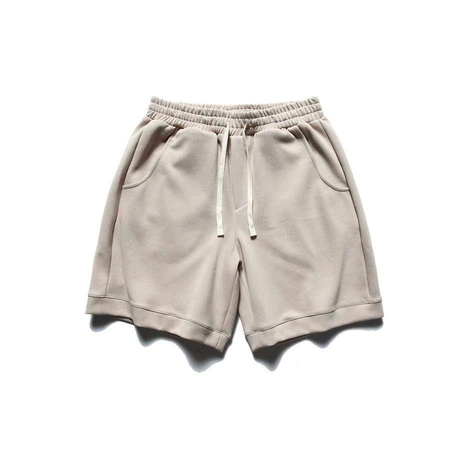 Beige drawstring shorts with elastic waistband, side pockets and turned hems, flat lay front view