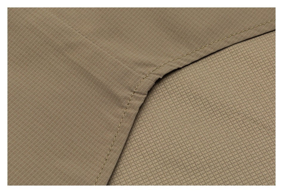 Close-up of a taupe garment seam beside a section of textured fabric.
