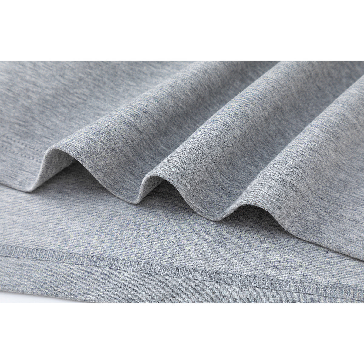 Close-up of the heather gray shirt's folded hem and stitched edge.