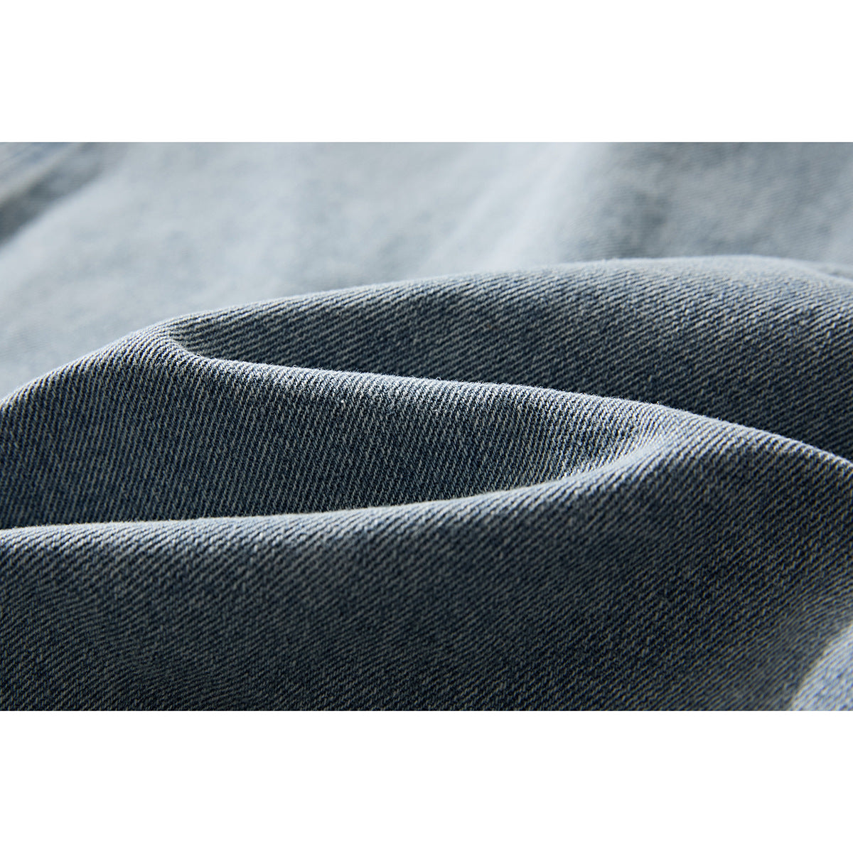 Macro view of the diagonal weave and texture of blue denim fabric.