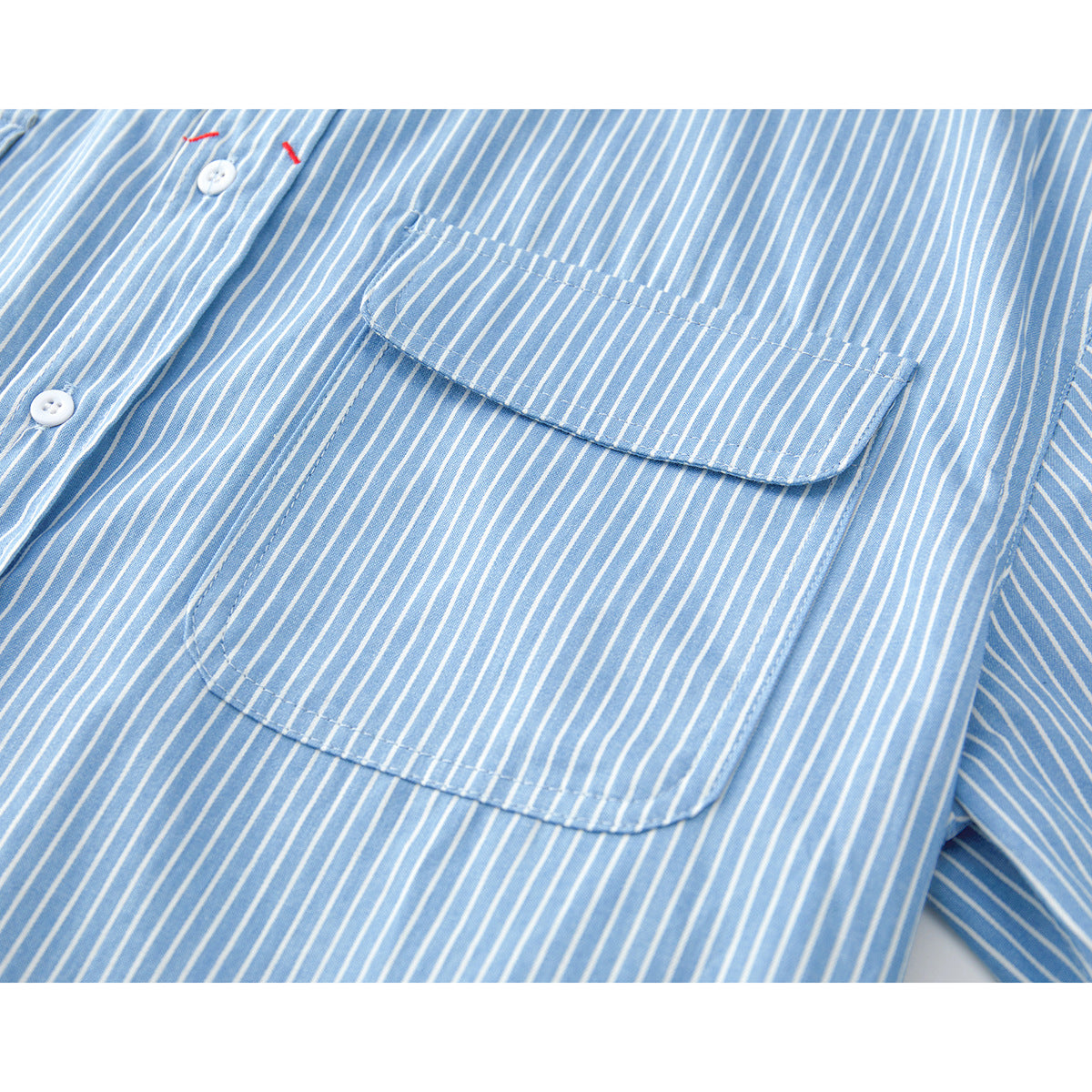 Close-up of a light blue and white striped shirt with a large buttoned chest pocket.