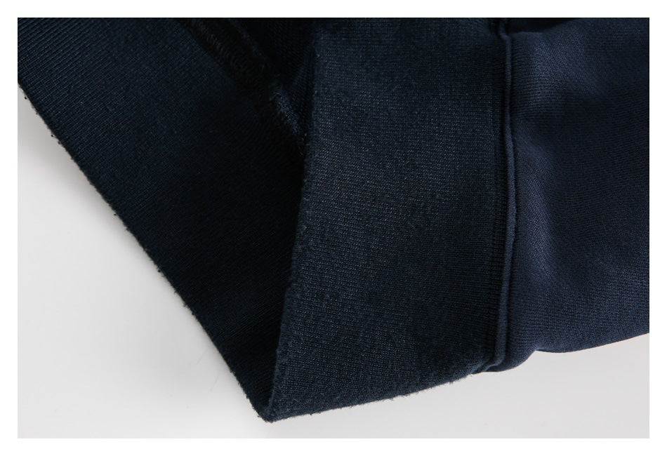 Close-up of dark navy garment fabric with a folded seam and edge.