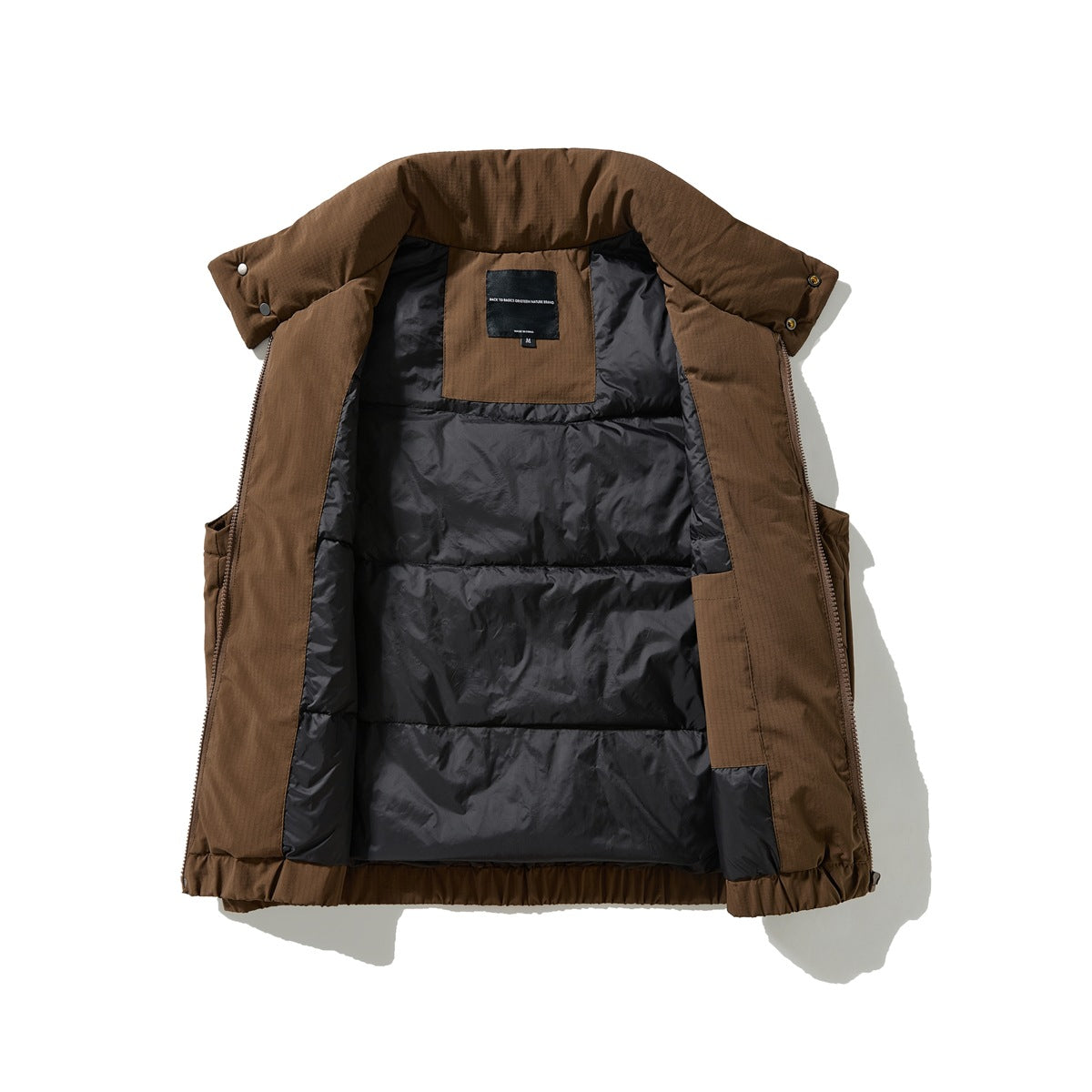 Brown vest opened to show its dark quilted lining, inner label, zipper, and snap-fastened collar.