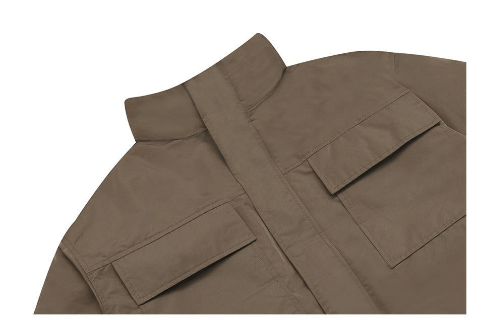 Close-up of a brown jacket's stand collar and two flap chest pockets.