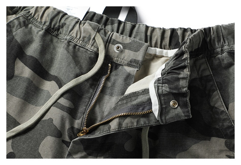 Close-up of the camouflage pants’ open fly, zipper, waistband, and inner facing.
