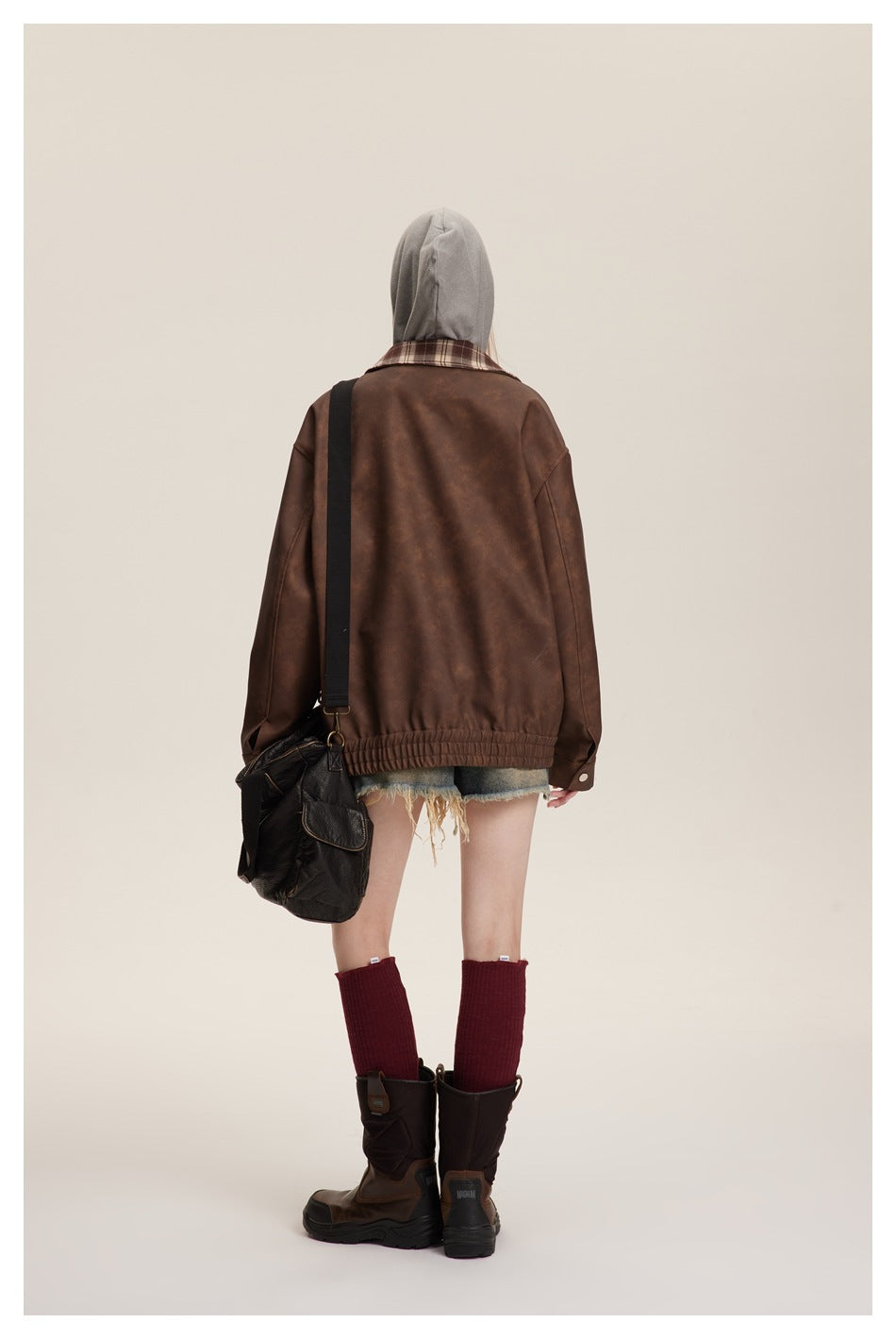 Full-length back view of a model wearing the brown jacket with a plaid collar and gathered hem.