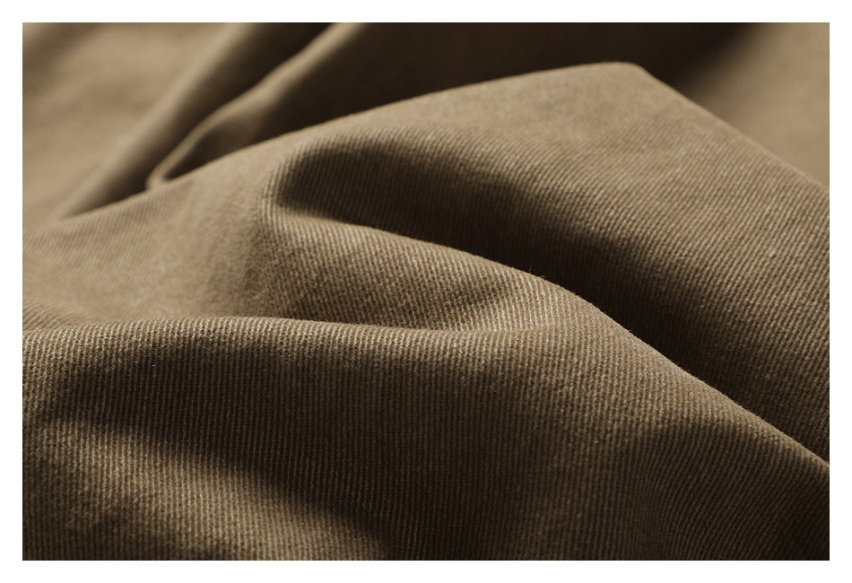 Macro view of the textured khaki-brown trouser fabric in soft folds.