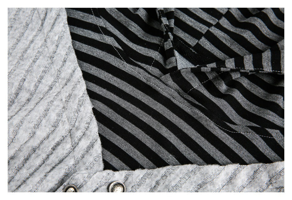 Close-up of striped black fabric beside the textured gray panel and two buttons.