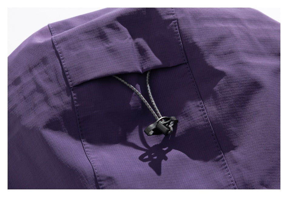 Close-up of a purple jacket hood with a gray drawcord and black cord lock.
