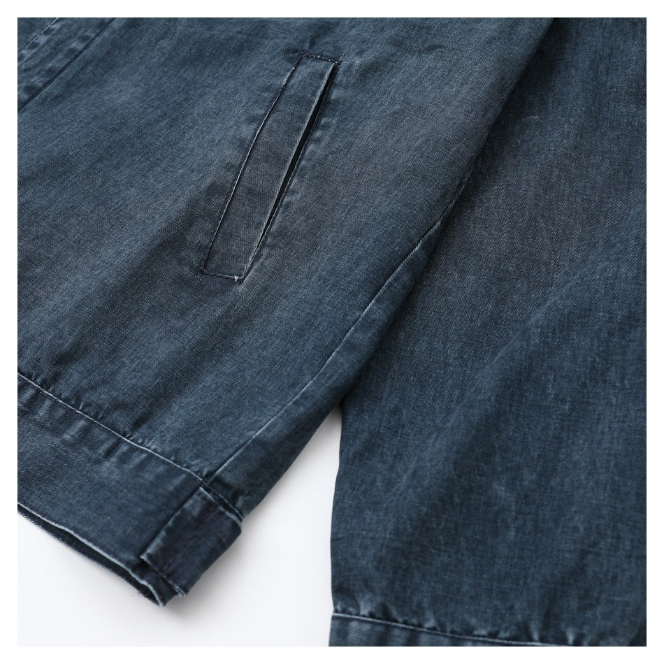 Close-up of a narrow welt pocket and stitched cuff on a dark blue denim garment.