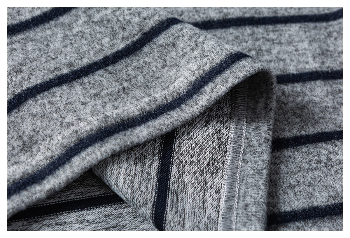 Close-up of heather gray striped knit fabric folded to show its inner texture and overlocked seam.