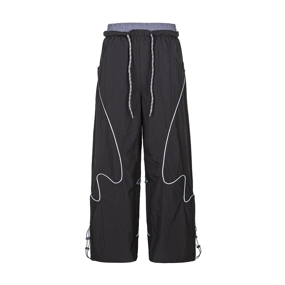 Black wide-leg pants with gray double waistband, drawstring, wavy light piping and toggle cords, front flat view