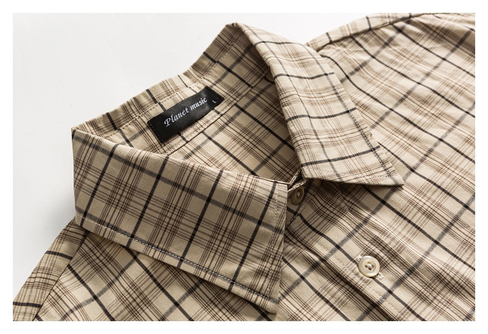 Close-up of the beige plaid shirt's collar, sewn neck label, and upper button placket.