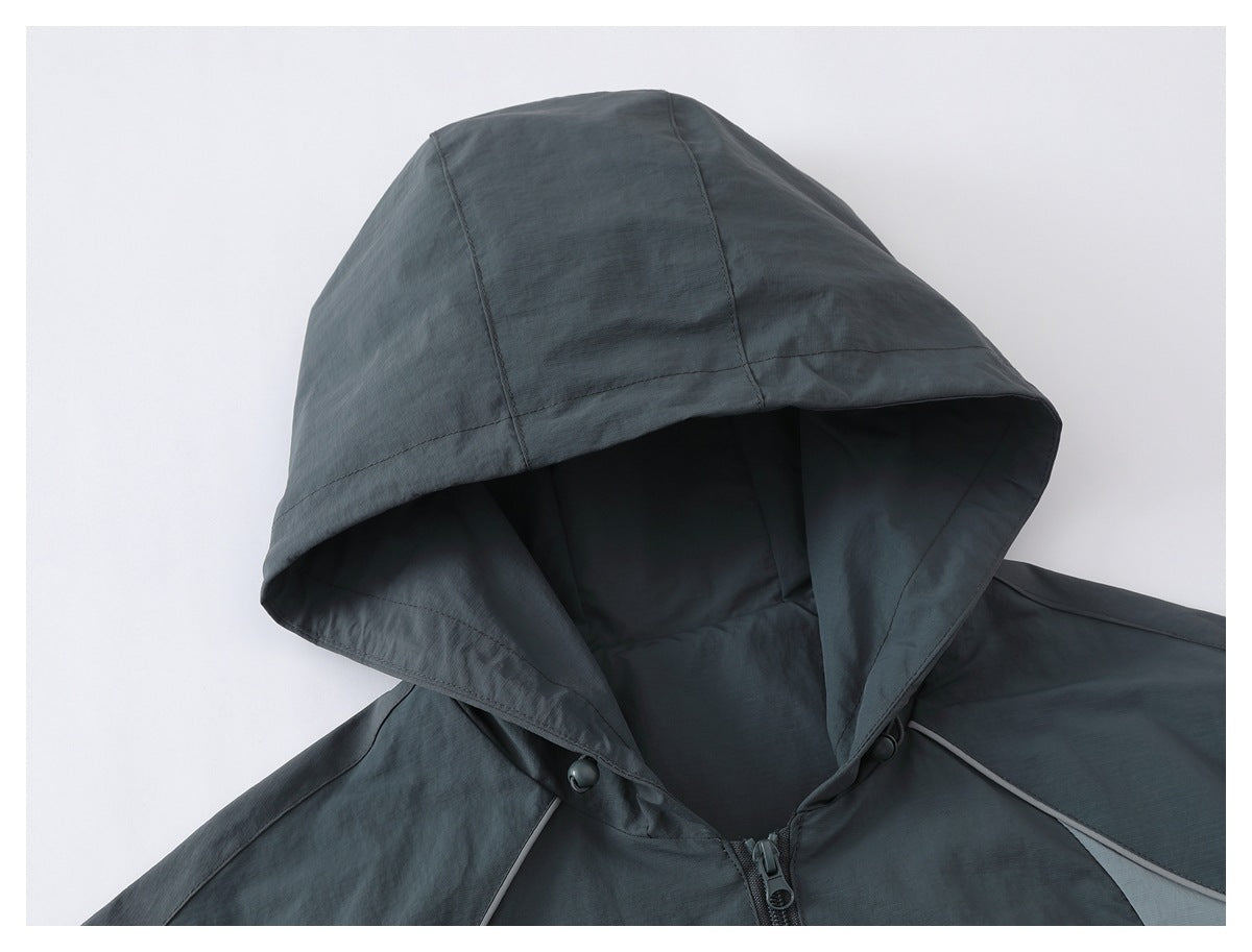 Close-up of a charcoal gray jacket hood and upper front with a center zipper and light gray piping.
