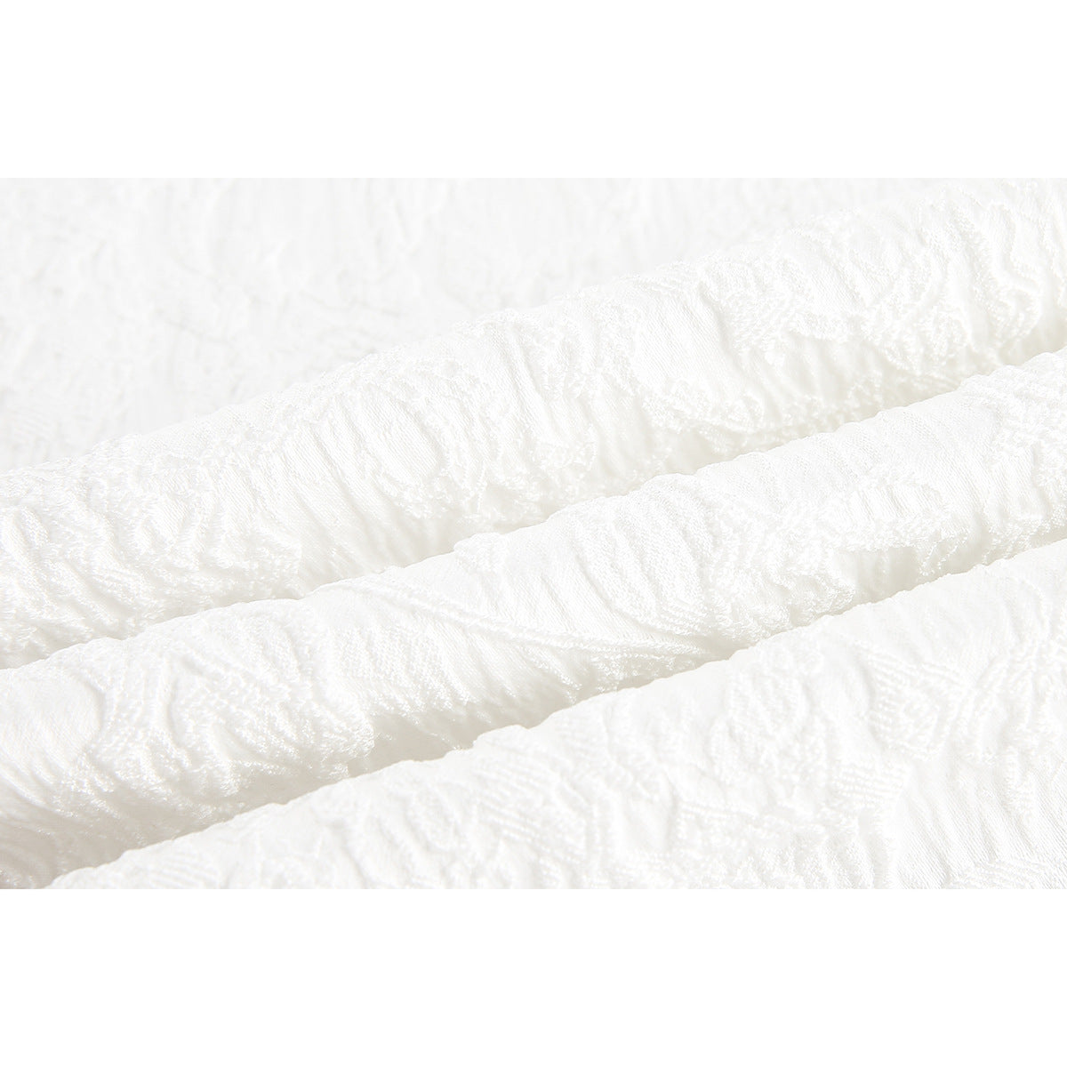 Close-up of raised white-on-white patterns in the shirt fabric.