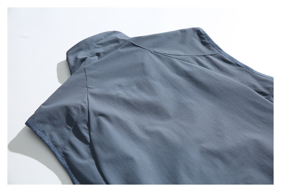 Close-up of the blue-gray garment's back panel, shoulder, neckline, and armhole seams.