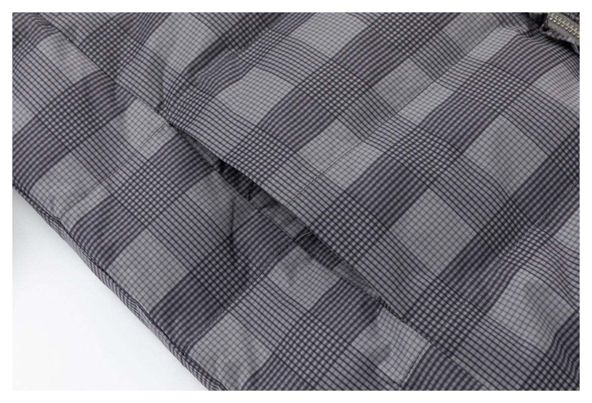 Close-up of gray-and-black plaid jacket fabric with overlapping panels and visible stitching.