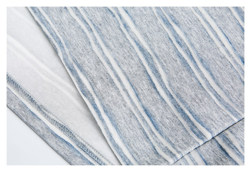 Close-up of striped gray knit garment showing its inside surface and overlocked seam.
