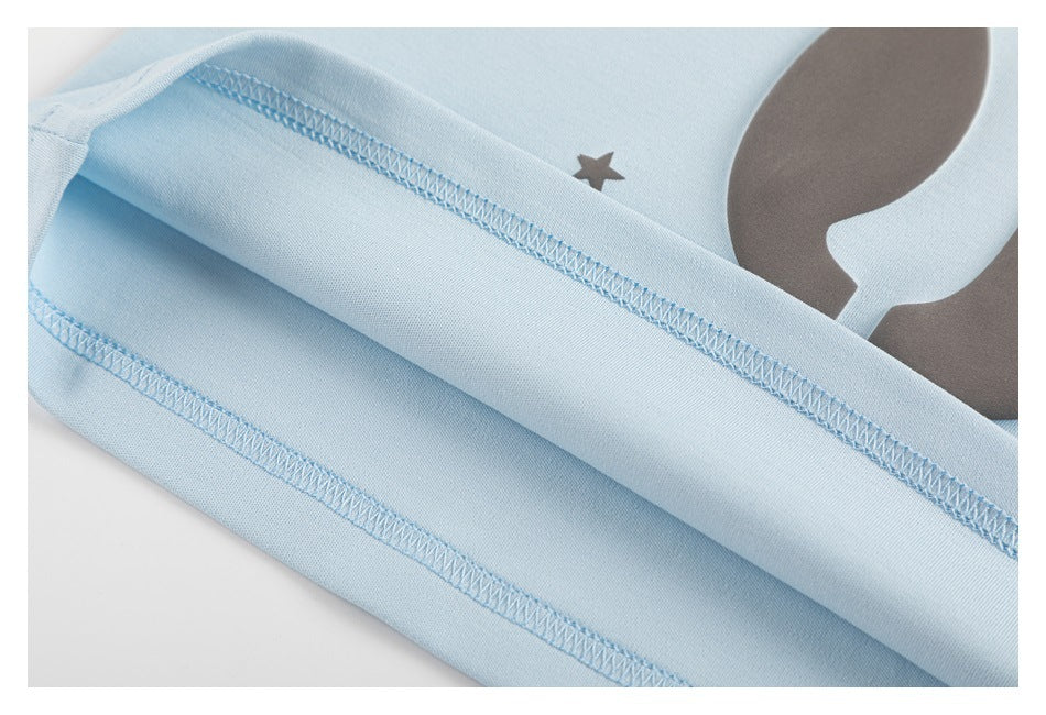 Close-up of the light blue T-shirt's folded hem and overlock stitching.