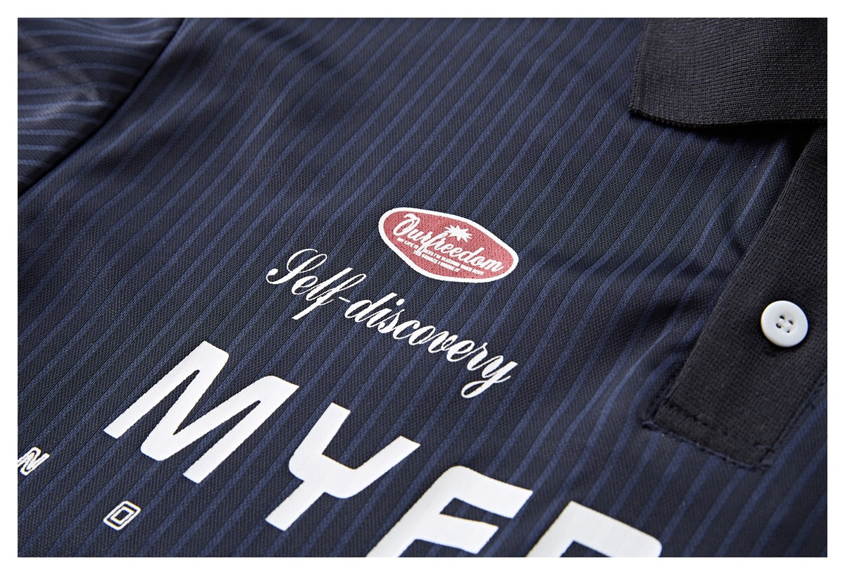 Close-up of a dark navy pinstriped polo shirt showing white chest lettering, a red oval graphic, black placket and white