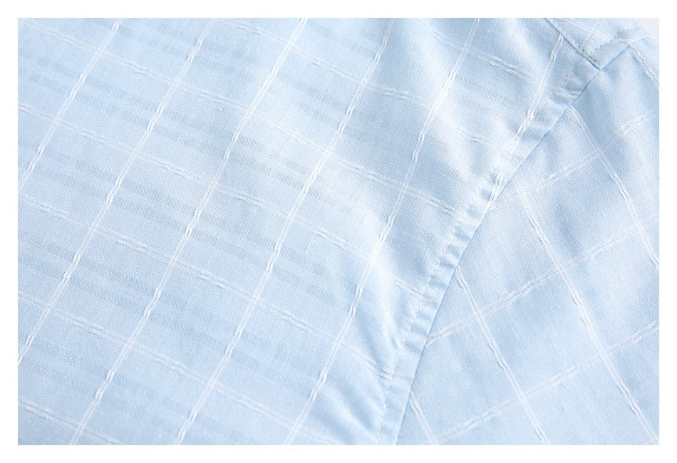 Close-up of pale blue windowpane-stitched shirt fabric and a curved seam.