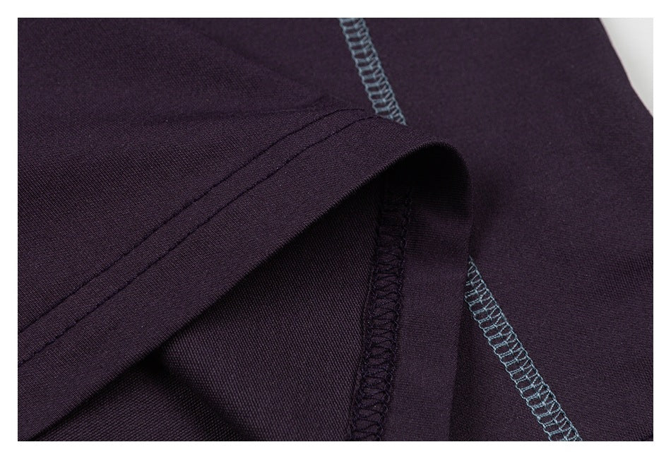 Close-up of a dark plum garment edge and blue-gray overlock seam.