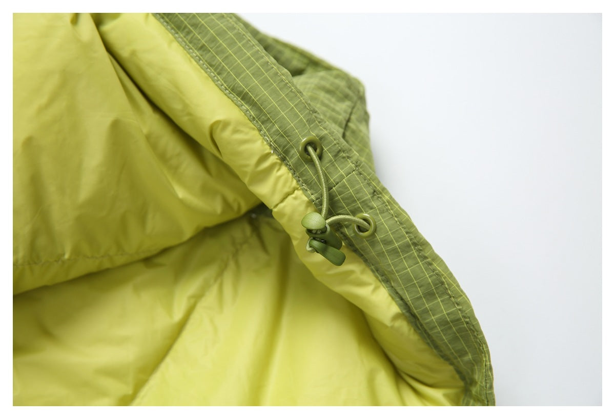 Close-up of a green drawcord and toggle beside the jacket's pale yellow-green lining.