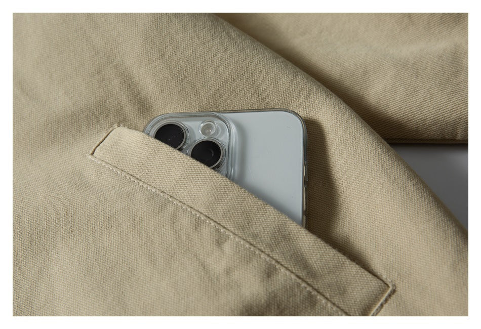 Close-up of a beige jacket pocket holding a smartphone.