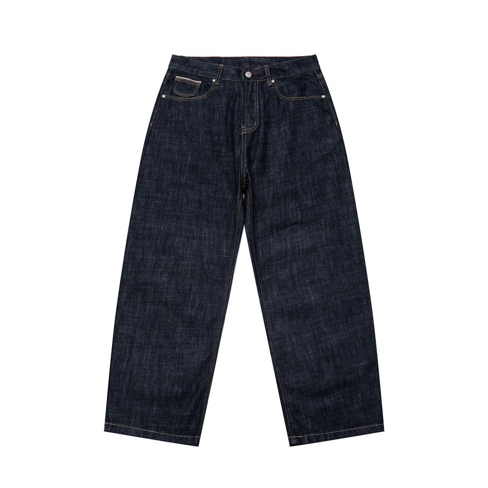 Front view of dark indigo wide-leg denim jeans with contrast tan stitching, flat on white