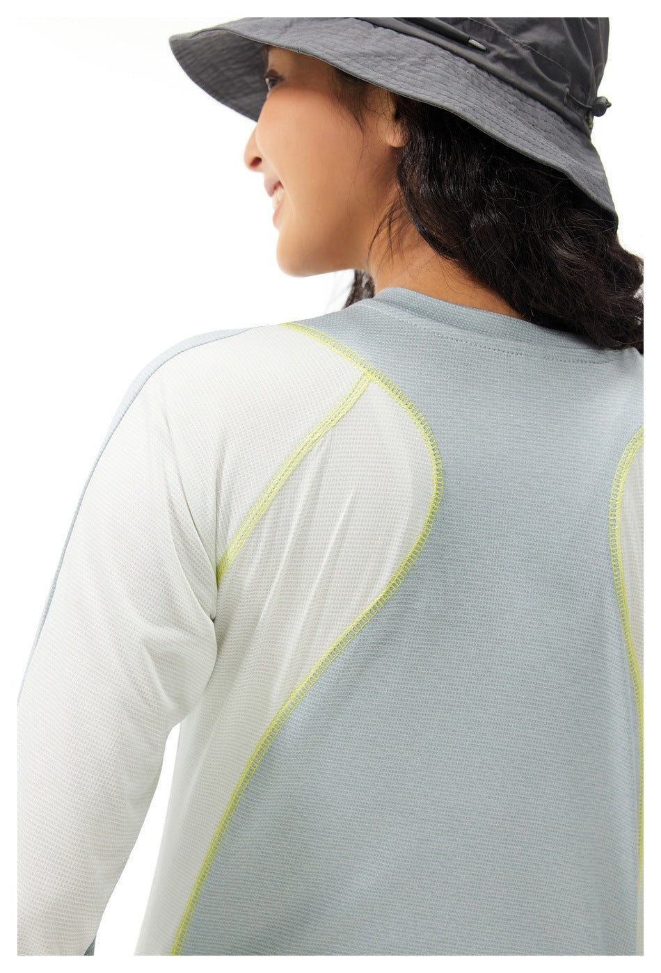 Close-up back view of a pale gray top with white sleeve panels and curved lime stitching.